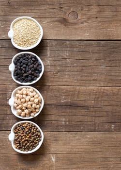 Cereals and legumes in bowls on a wooden table