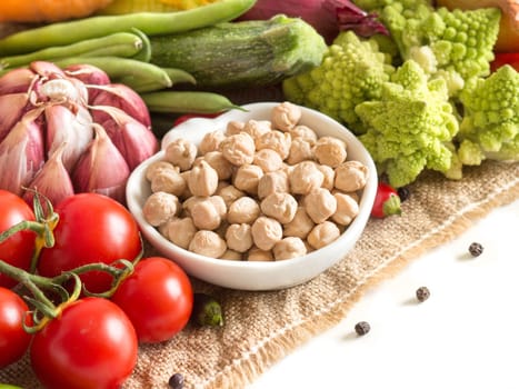 Chickpea with vegetables on burlap isolated on white