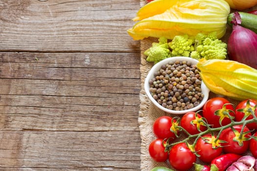 Raw organic roveja beans and vegetables on wooden table