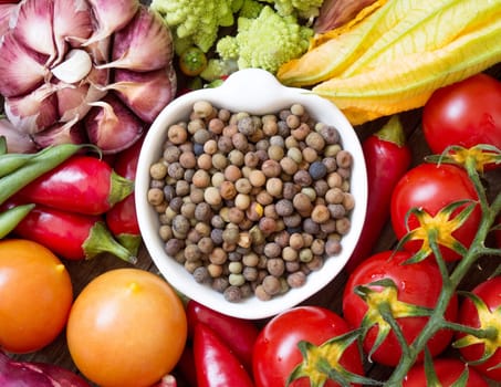 Raw organic roveja beans in a bowl and vegetables