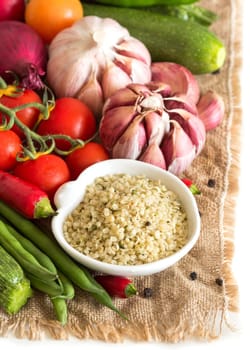 Raw organic hemp seeds in a bowl and vegetables