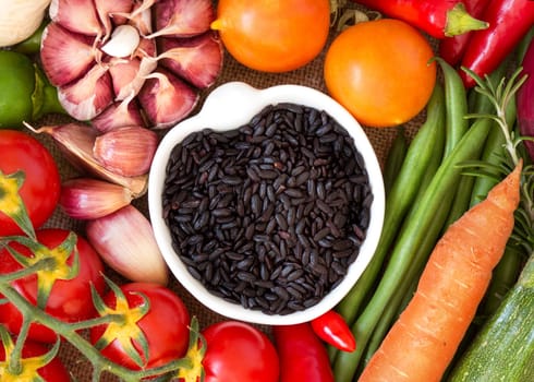 Black organic rice in bowl and vegetables