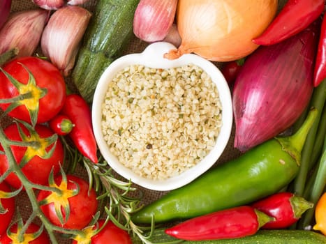 Raw organic hemp seeds in a bowl and vegetables