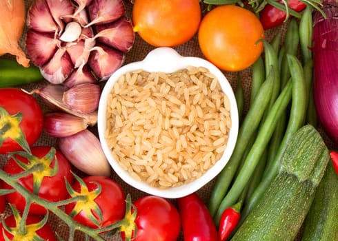 Whole upolished organic rice in bowl and vegetables