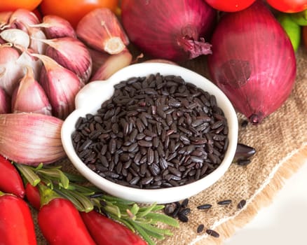 Black organic rice in a bowl and vegetables