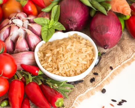 Whole upolished organic rice in bowl and vegetables