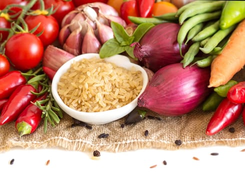 Whole upolished organic rice in bowl and vegetables