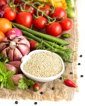 Raw organic quinoa in a bowl and vegetables