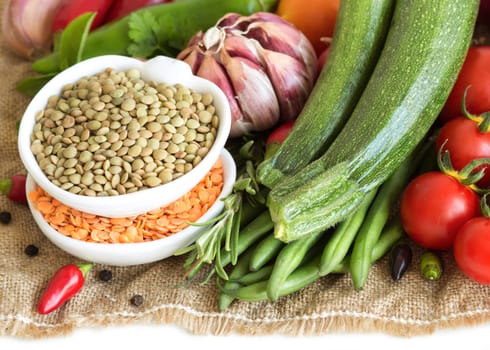 Red and green lentils and vegetables isolated on white