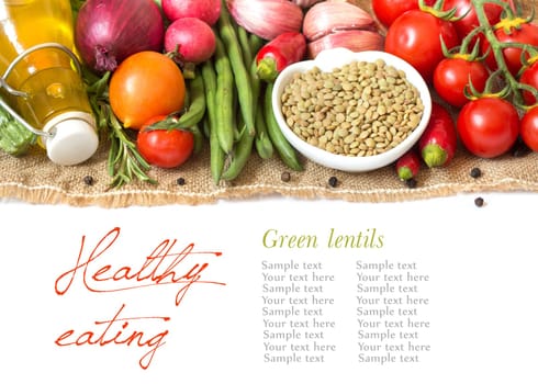 Green lentils in bowl and vegetables isolated on white