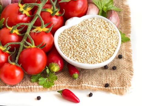 Raw organic quinoa in a bowl and vegetables