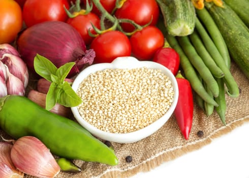 Raw organic quinoa in a bowl and vegetables