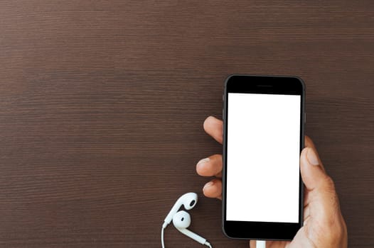 hand hold phone white screen on wood table, mockup new smart phone modern style matte black color