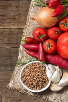 Raw Organic buckwheat and vegetables on wooden table