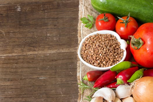 Raw Organic buckwheat and vegetables on wooden table
