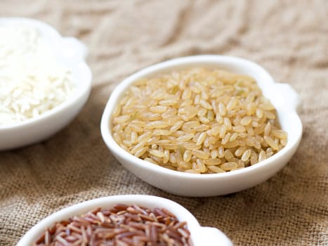 Variety of rice in bowls on wooden table