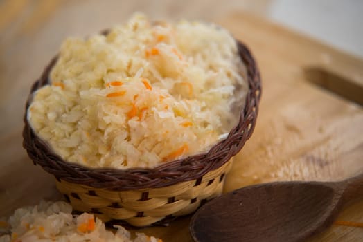 sauerkraut in bowl on wooden plate