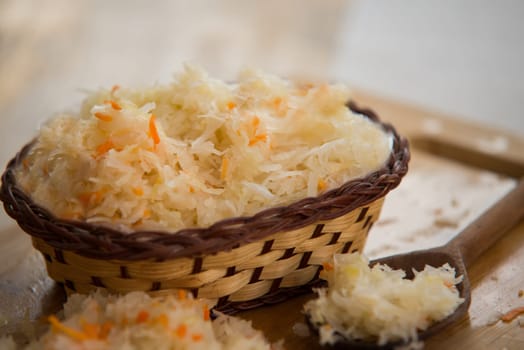 sauerkraut in bowl on wooden plate