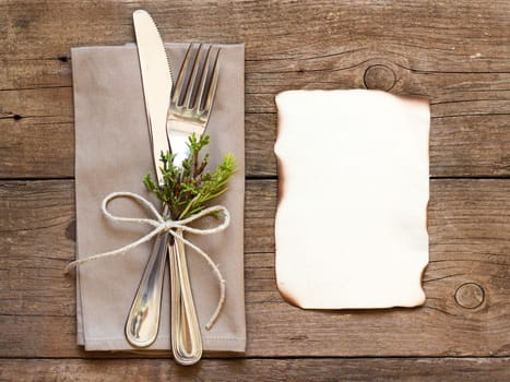 Rustic Table setting and old burned paper on old wooden table