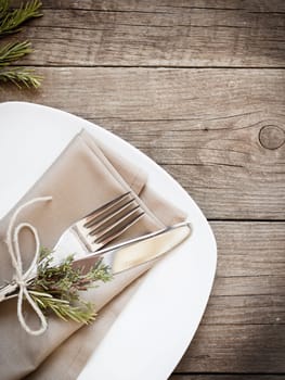 Rustic Table setting with juniper and rosemary decor on old wooden table