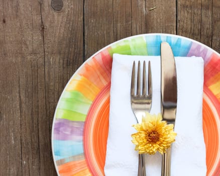 Colorful Table setting with yellow flower on old wooden table