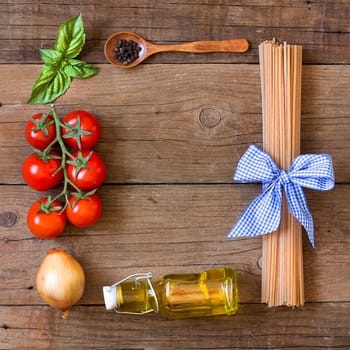 Ingridients for pasta with tomato sauce - tomatoes, onion, basil, extra vergin olive oil, pepper and whole durum spaghetti