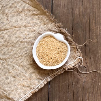 Raw Organic Amaranth grain in a bowl on wooden table