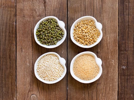 Raw Organic Amaranth and quinoa grains, wheat and mung beans in small bowls