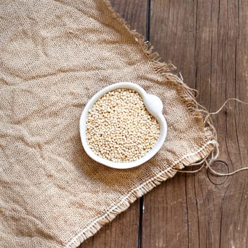 Raw Organic Quinoa grain in a bowl on wooden table