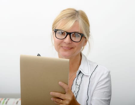 a mature woman writing on a notebook
