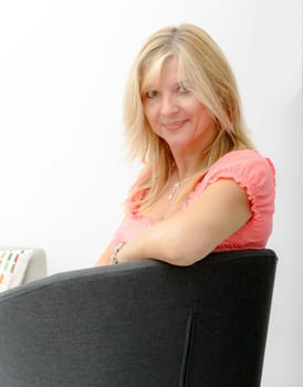 Portrait of blond mature woman relaxing in armchair