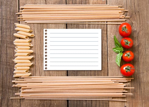 Pasta, tomatoes and basil on wooden background