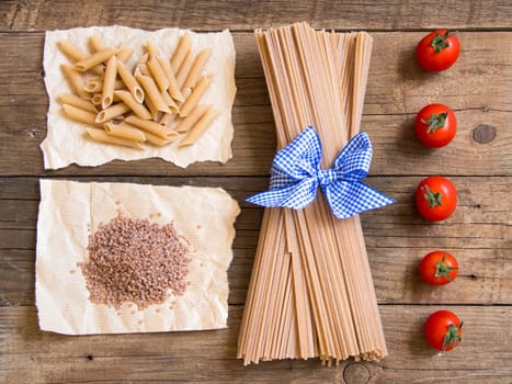 Pasta and tomatoes on wooden background