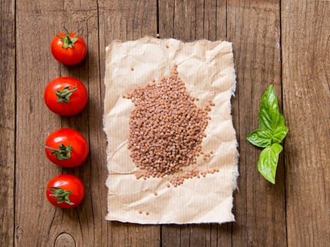 Pasta, tomatoes and basil on wooden background