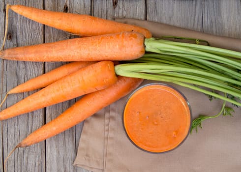 Fresh carrot juice on a wooden background