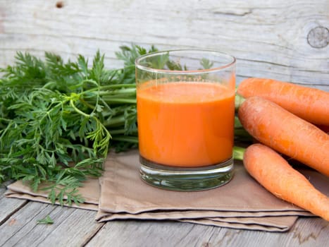 Fresh carrot juice on a wooden background