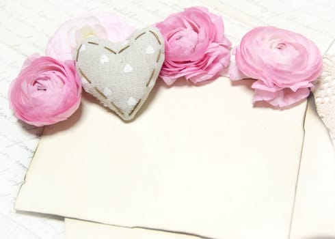 Ranunculus flowers, paper and heart background