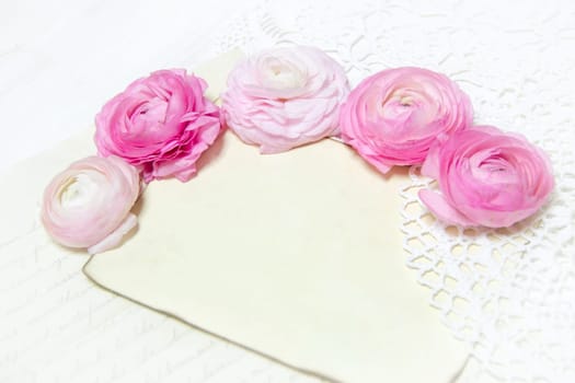 Ranunculus flowers, paper and heart background