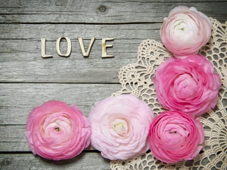 Ranunculus flowers and letters LOVE on wood