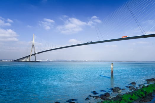pillar of the bridge "Pont de Normandie"" reflected in the Seine river at Le Havre, France"