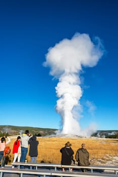 YELLOWSTONE NATIONAL PARK, WY - SEPTEMBER 11: Crowd watches an eruption of Old Faithful in Yellowstone National Park on September 11, 2015