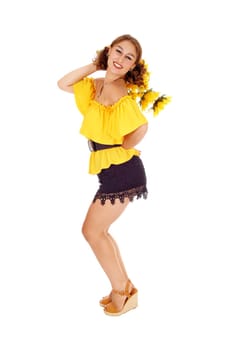 Gorgeous young woman in a yellow blouse and black shorts holding .some sunflowers, standing in profile, isolated for white background..