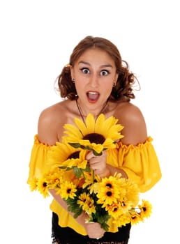 Gorgeous young woman in yellow blouse holding a bunch of sunflowers, .and screaming for fun, standing isolated for white background..
