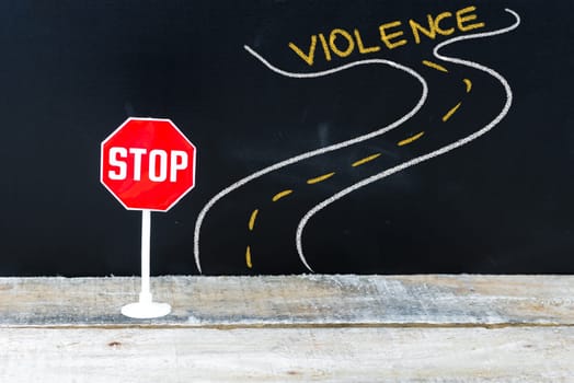 Mini STOP sign on the road to VIOLENCE, hand drawing over chalkboard