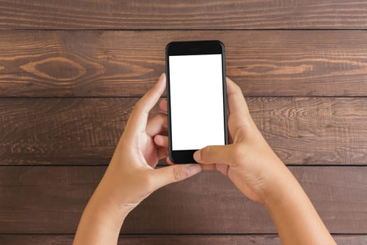 phone in woman hand showing white screen on wood table, mockup new phone style jet black color