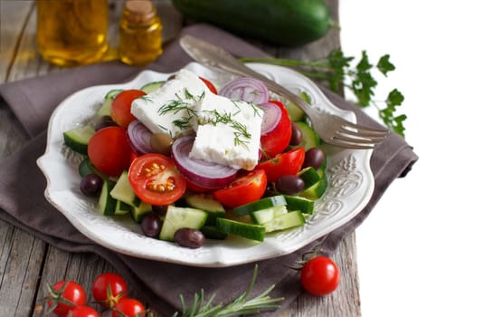 Greek salad with tomatoes, feta cheese, cucumbers, onions and olives