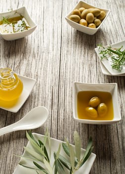 Olive oil with fresh herbs on wooden background