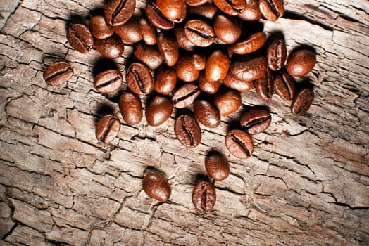 Coffee beans on a wooden background close up