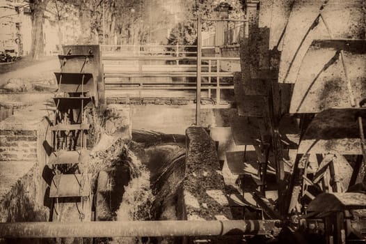 Old wheels of a watermill. Vintage style picture. Adding grain to give an old photo effect.