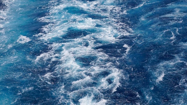 The foam on the blue water of sea